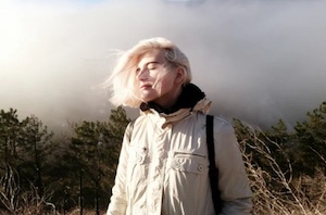 woman in sun hair blowing clouds