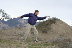 man doing qigong with mountains in background