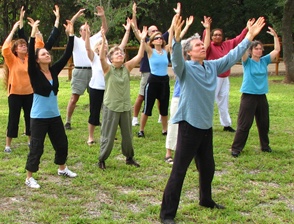 group practicing qigong with arms raised