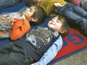 children lying down meditating